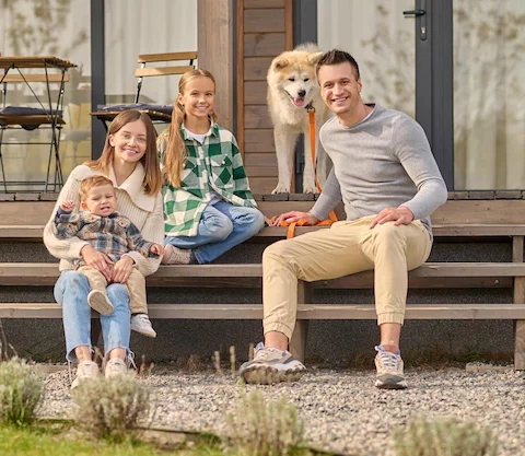 family-sitting-on-steps-looking-at-camera-and-dog_259150-59359